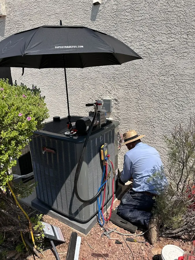 HVAC technician performing outdoor AC maintenance in Avon